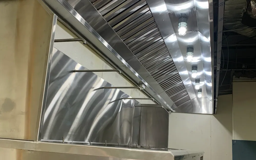 Campana de extracción industrial en acero inoxidable con filtros de bafle e iluminación estanca integrada