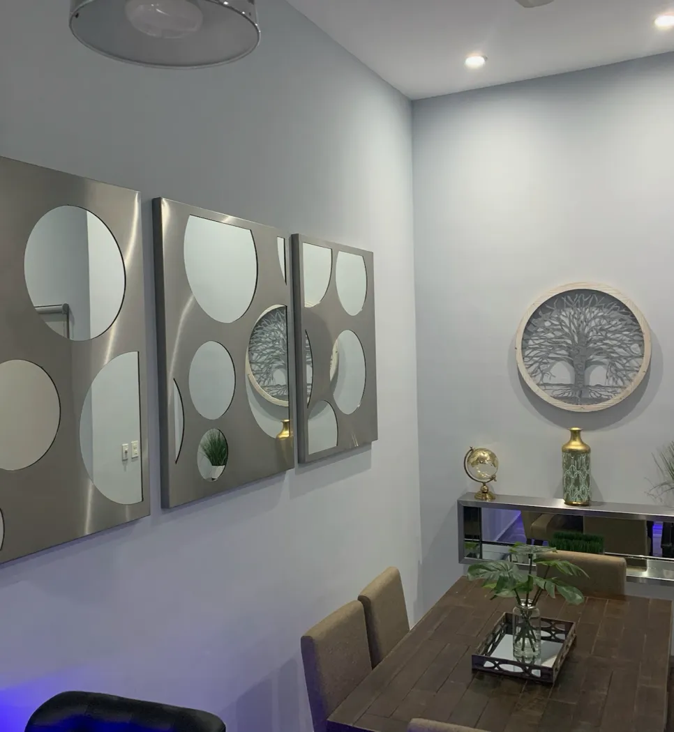 Paneles de acero con espejos circulares junto al comedor y mueble flotante de acero